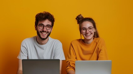 Young smiling happy cheerful caucasian couple two friends family man woman together in yellow casual clothes hold use work on laptop pc computer isolated