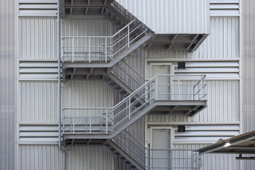 fire exit stair of large factory building. galvanise metal stair step of the big cargo. - obrazy, fototapety, plakaty