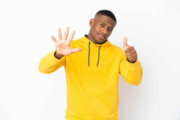 Fototapeta premium Young latin man isolated on white background counting six with fingers