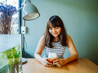 Beautiful asian woman enjoy drinking ice coffee morning time near window in cafe shop lifestyle ideas concept