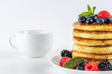 Delicious pancakes with fresh berries on white table. Food concept.