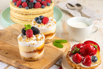 Sweet desserts with fresh berries on wooden background.