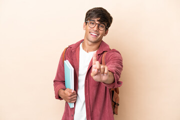 Young student caucasian man isolated on ocher background showing and lifting a finger
