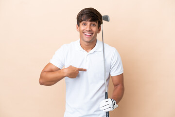 Young golfer player man isolated on ocher background with surprise facial expression