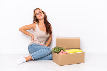 Young Russian girl sitting on the floor isolated on white background suffering from backache for...