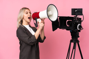 Reporter woman holding a microphone and reporting news over isolated pink background shouting through a megaphone
