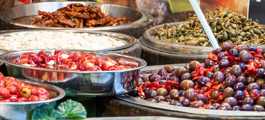 Food stall at a market in Catania, Sicily. Tomatoes, olives, spring onions and other delicacies - obrazy, fototapety, plakaty