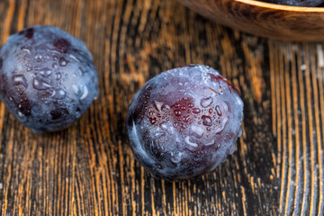 Wet purple plum on the table, fresh harvest