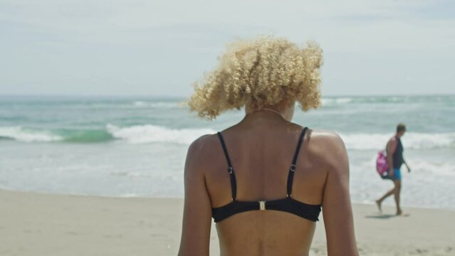 Light skin model walking on the beach, black bikini, 19 year old model