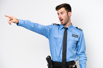 Young police caucasian man isolated on white background pointing away