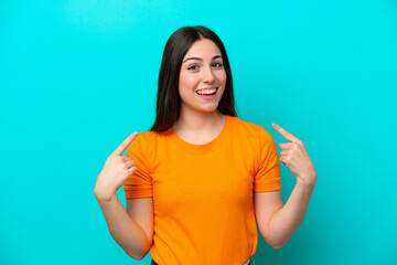 Young caucasian woman isolated on blue background giving a thumbs up gesture