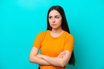 Obraz premium Young caucasian woman isolated on blue background keeping the arms crossed