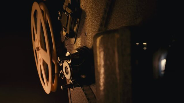 Retro projector playing motion picture. dark room. Timeless flicker of old films