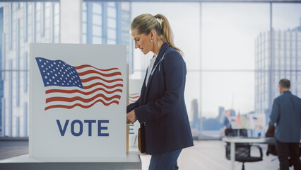 Young Businesswoman Filling Out a Ballot Next to a Voting Booth on the Day of National Elections in the United States. Concept of People Visiting a Polling Precinct to Vote For Favourite Candidate
