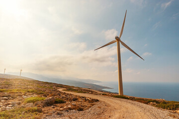 Wind turbines on a sunny day on sky background. Green energy generation concept.