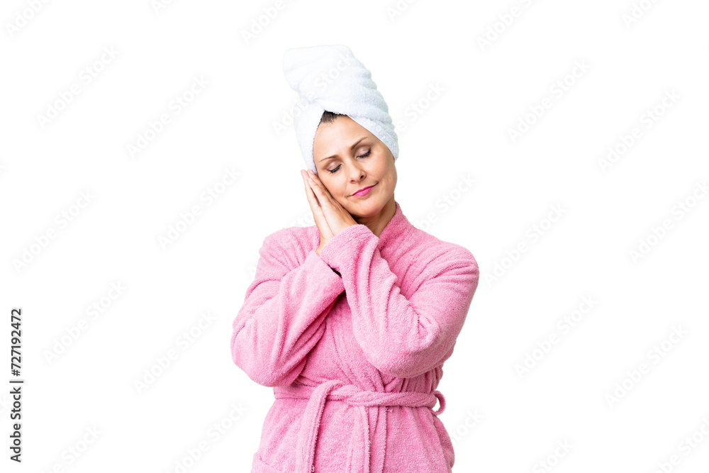 Canvas Prints Middle age caucasian woman in a bathrobe over isolated background making sleep gesture in dorable expression