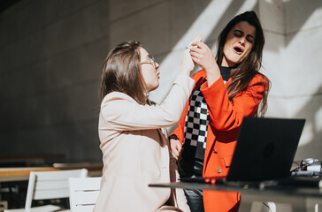 A spontaneous moment as two professional women in smart attire engage in an arm wrestling match on a sunny day, showcasing a blend of competition and camaraderie.