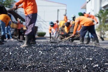 Blurred image of pavement maintenance work using human labor