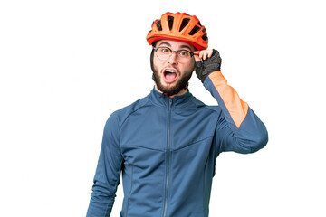 Young cyclist man over isolated chroma key background with glasses and surprised - obrazy, fototapety, plakaty