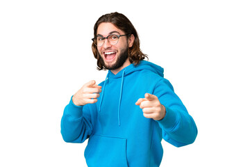 Young handsome man over isolated chroma key background surprised and pointing front