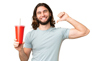 Young handsome man holding soda over isolated chroma key background proud and self-satisfied