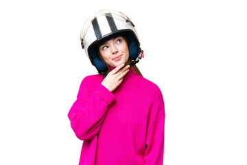 Young pretty woman with a motorcycle helmet over isolated chroma key background looking up while smiling