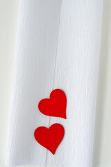 red wooden heart embellishments on folded crepe paper