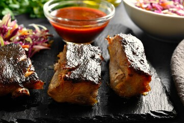 Sliced spicy grilled spare ribs on black slate plate
