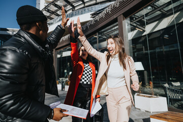 Joyful multiracial business teammates celebrating successful project outside office building.
