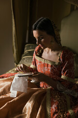 Renaissance woman sewing on her bed