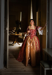 Fototapeta na wymiar Lady in renaissance gown in dark interior