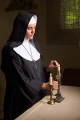 Vintage catholic nun lighting candles