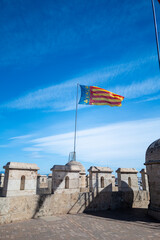Valencia, Spain - May 12 2023 : The city of valencia community flag flys high above the portal...