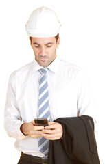 Handsome and smart engineer in suit and white shirt and Wearing a white safety engineer hat with hand holding smartphone or tablet