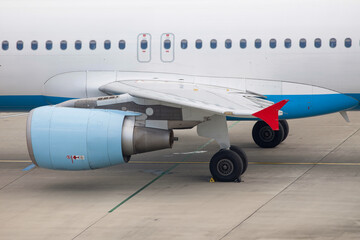 Obraz premium detailled close-up of the landing gear, wing and engine of an airplane on the ground