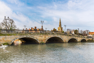 Obraz premium A view from the southern shore along the town bridge over the River Great Ouse in Bedford, UK on a bright sunny day