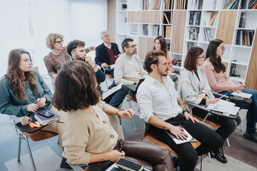 Professional men and women of various ages engaging in a business workshop in a contemporary office...