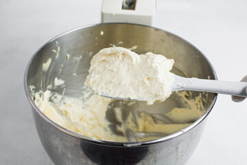 cream buttercream for decorating cake, silky smooth american buttercream on a spatula, overhead view of smooth buttercream