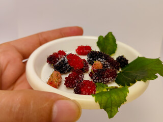 close up of fresh ripe mulberry fruit in a small white plate
