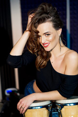 Fototapeta premium Beautiful young woman plays the bongos in recording studio