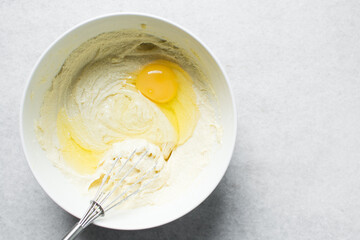 Creaming butter, sugar and egg with a whisk, the process of making a cake, mixing butter, sugar and egg to make a cake