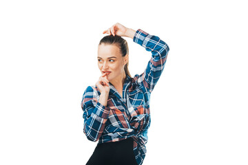 Young woman in plaid shirt and black pants on white background in the studio straightens her hair with her hand.