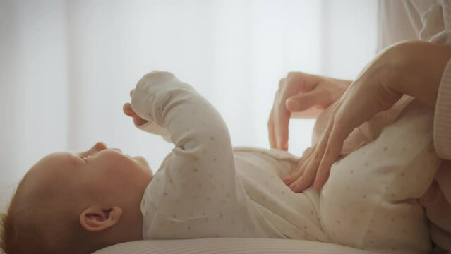 The mother, carefully caring for her baby, massages the tummy, relieving discomfort. Modern methods of caring for a newborn include massage to relieve pain and colic