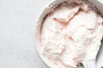 pink buttercream in a white mixing bowl, American buttercream in a bowl for icing cake, frosting for decorating cake