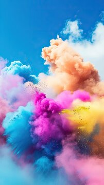 Clouds of colored smoke against a blue sky.