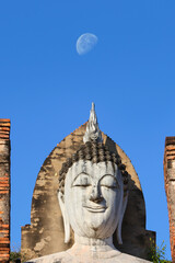 Amazing face of Buddha statue surmounted by the moon during the day at Sukhothai Historical Park, Thailand