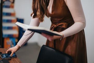 Professional woman in stylish attire checking time while reviewing documents.