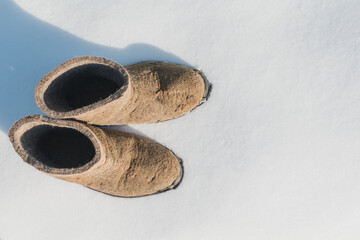 Short felt boots stand in the snow