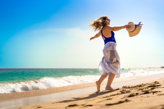 Beautiful woman walking on sunny beach Santa Maria, Sal Island, Cape Verde

