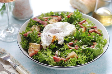 A bowl with salad lyonnaise served for lunch
